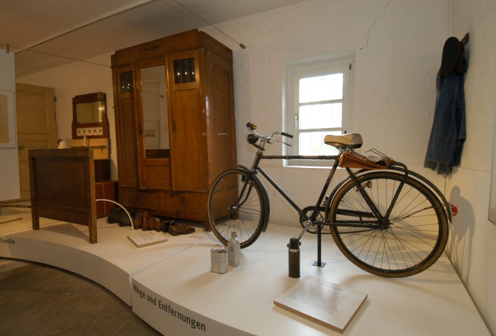 view into the exhibition, with an old bike and furniture