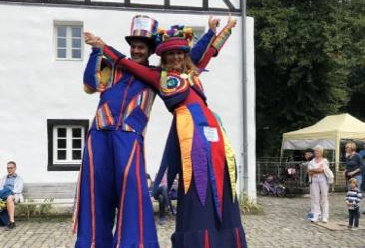 Two colorfully dressed stilt walkers.