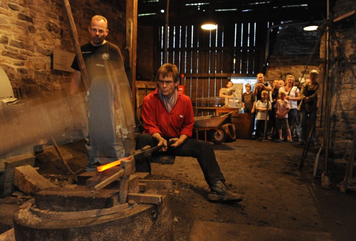 smith and his assistant at work at the forging hammer