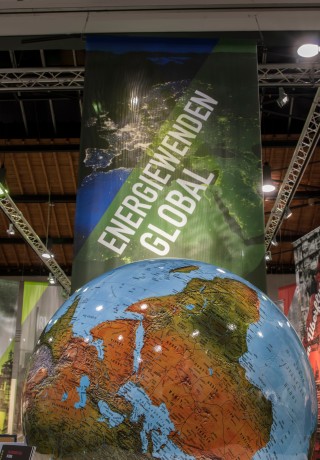 Großer Globus, darüber Banner mit der Aufschrift "Energiewenden global"