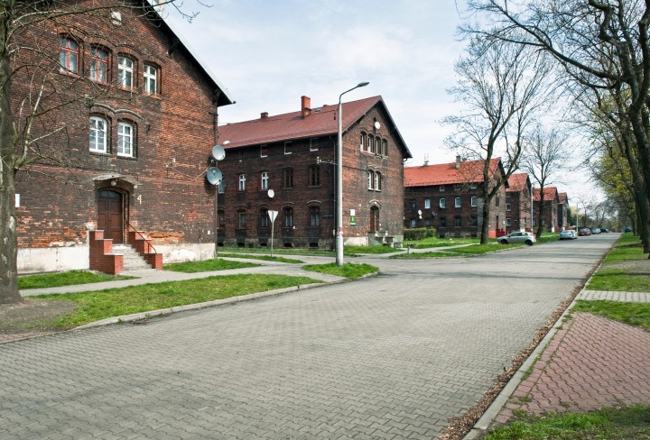 Mehrere Backsteingebäude der Siedlung "Borsigwerk" mit einer breiten Straße vor den Gebäuden. 
