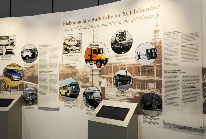 Blick auf eine Ausstellungswand mit historischen Elektromobilen
