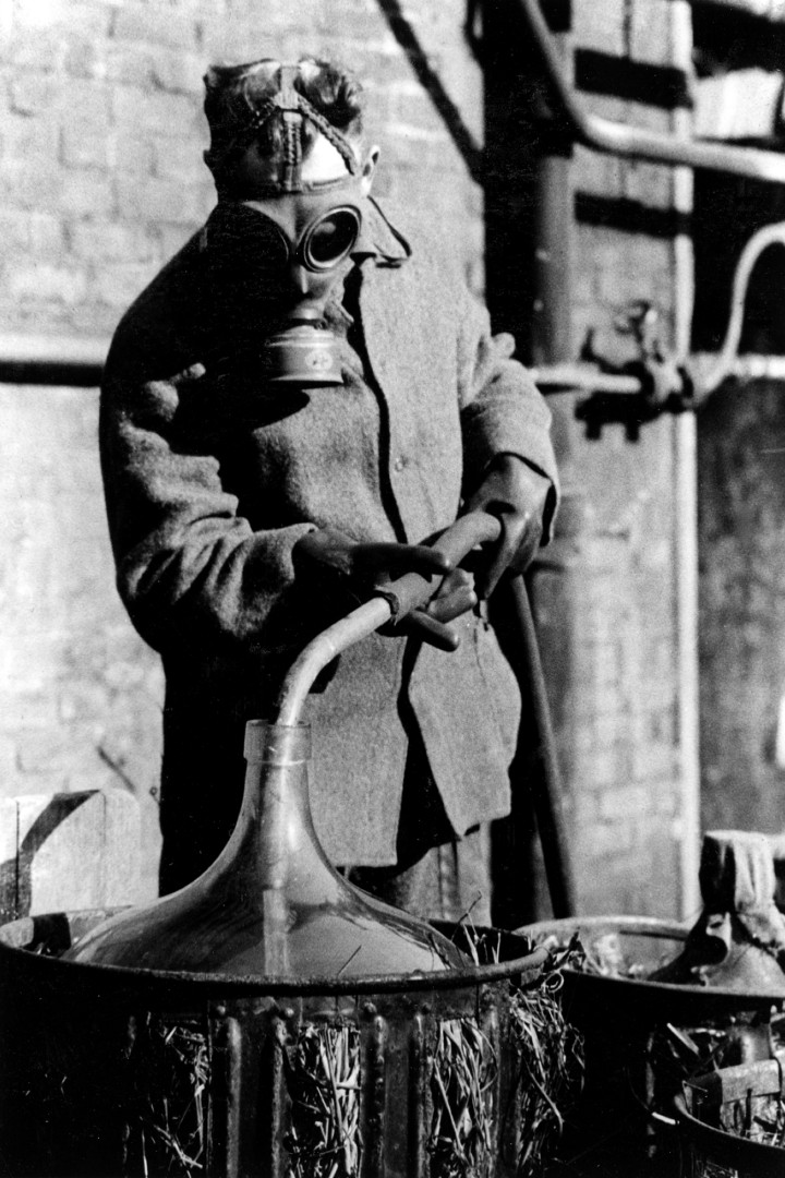 Historisches Schwarz-Weiß-Foto eines Arbeiters mit Gasmaske in der Salpetersäureanlage bei der Ruhrchemie AG