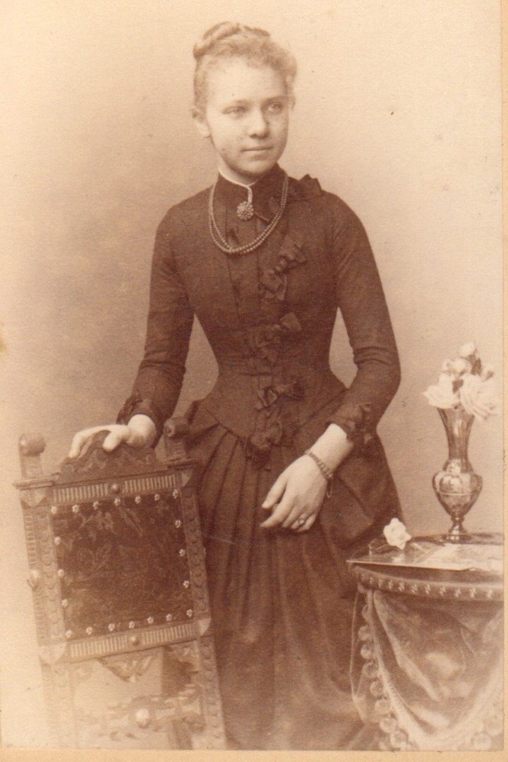 Historisches Schwarzweiß-Foto einer Frau in einem schwarzen, langen Kleid