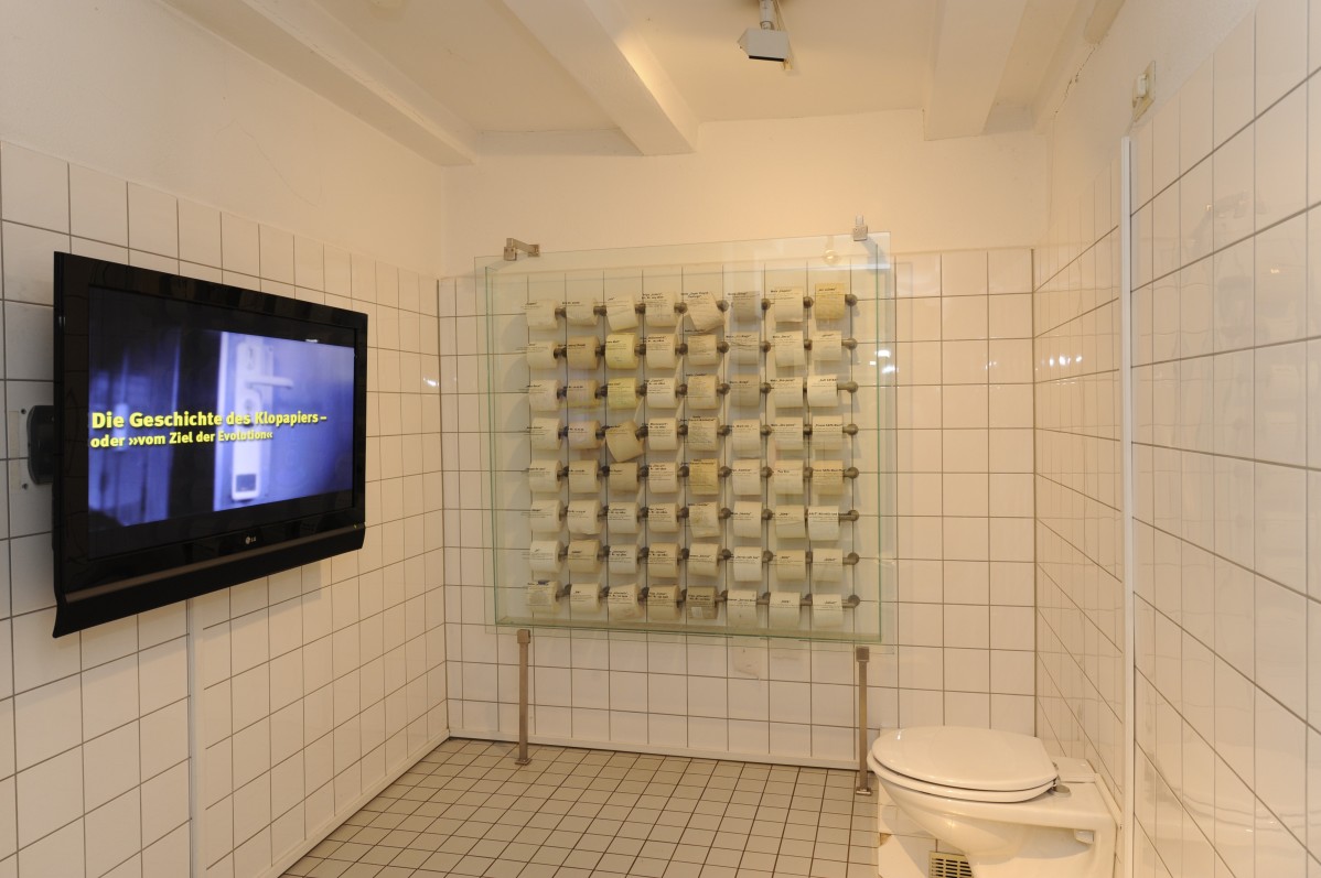Nachgestelltes Badezimmer mit WC, Schautafel und Bildschirm