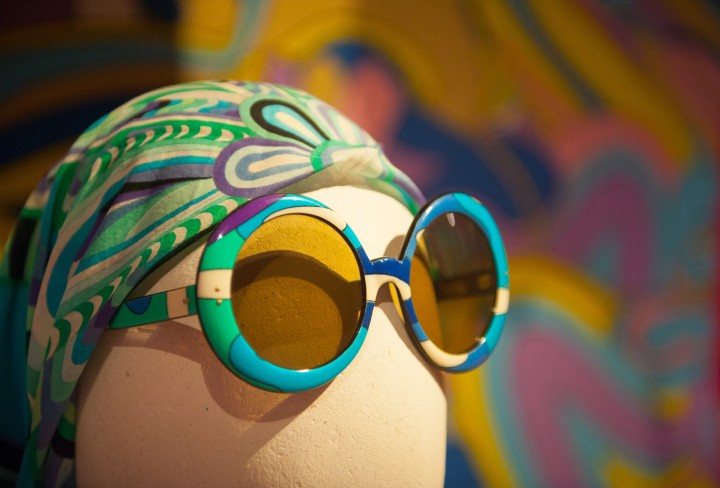 Kopf einer Figurine bekleidet mit einer großen runden Sonnenbrille und einem Kopftuch mit Paisleymuster.