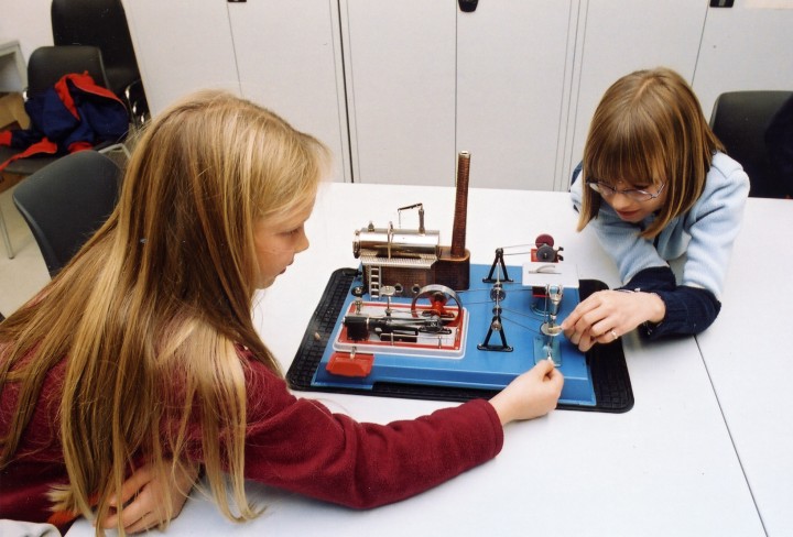Children play on the model of a steam engine