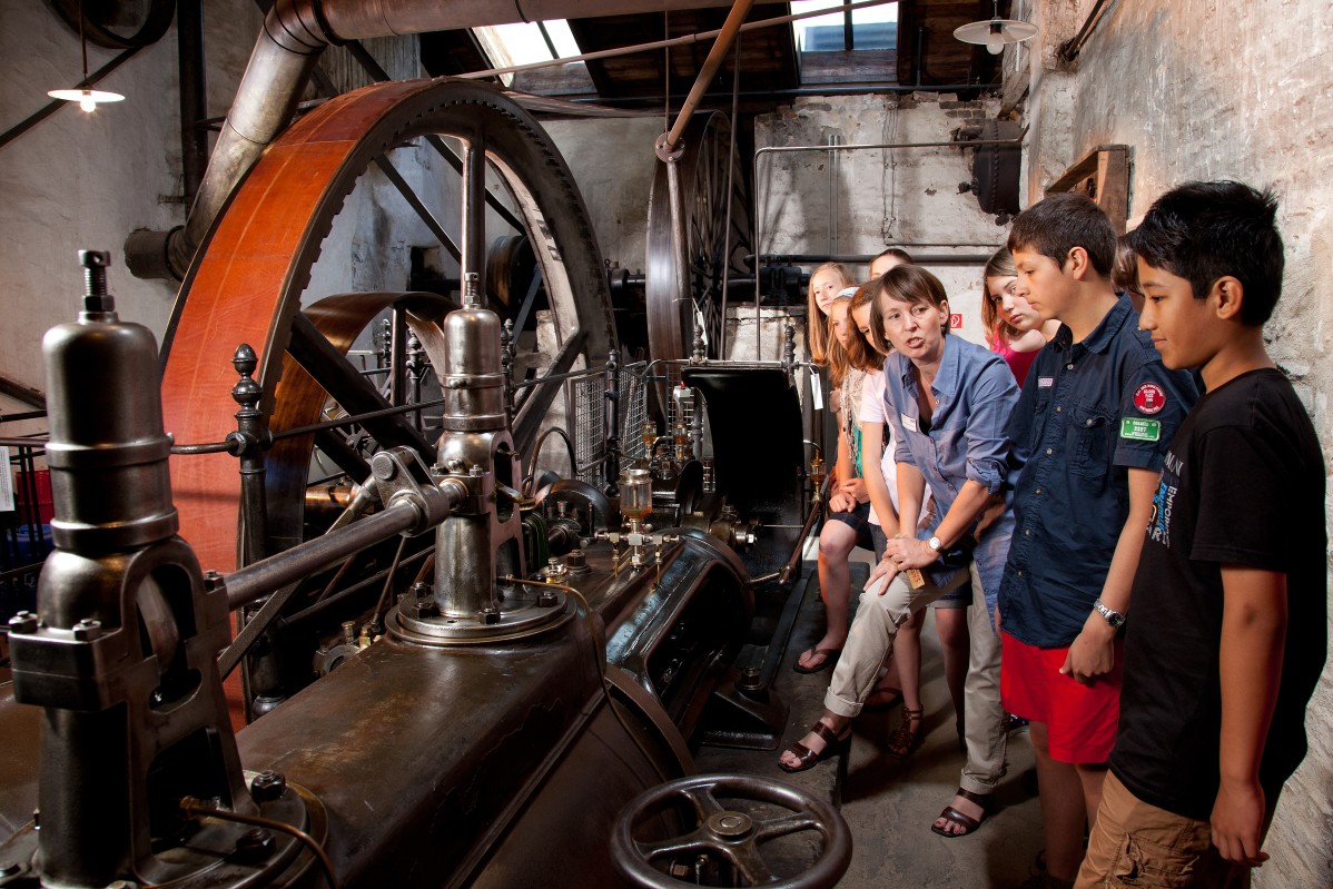 School class with a tour guide at the steam engine