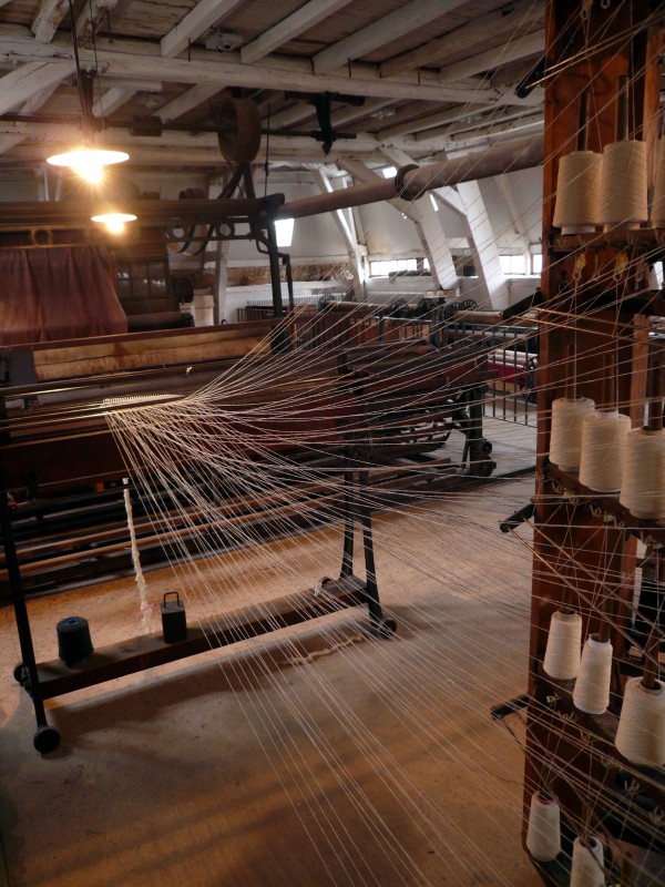 Webereivorbereitung in der Fabrik mit vielen Garnfäden, die zu einer Webkette gebündelt werden. 