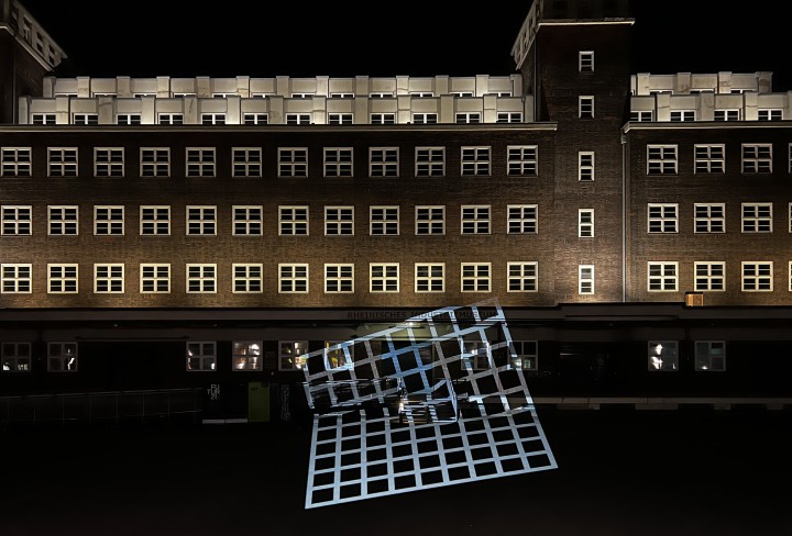 Gitter aus Licht vor einem beleuchteten Gebäude im Dunkeln
