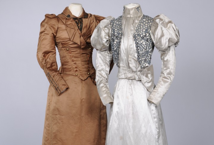 Zwei historische Gesellschaftskleider, eines braun und eines silber-weiß