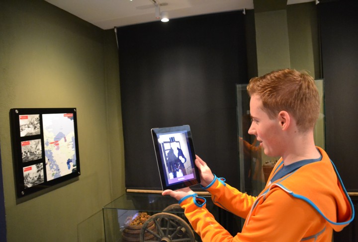 Junger Mann schaut auf einen Tablet-Computer in der Ausstellung der St. Antony-Hütte