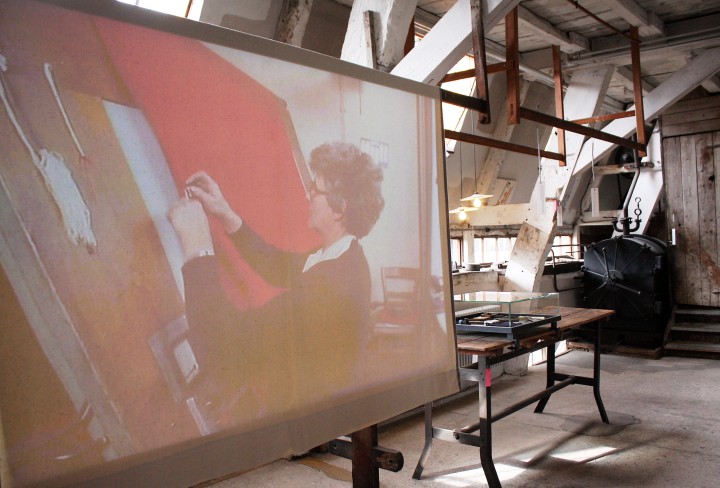 Foto zeigt eine Videoleinwand mit einer Arbeiterin in der Tuchfabrik