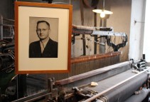 Foto zeigt das Portrait von Tuchfabrikant Kurt Müller über einem Webstuhl