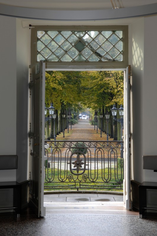 Blick durch geöffnete Balkontür des Cafés im Herrenhaus Cromford mit Ausblick in den Cromford-Park