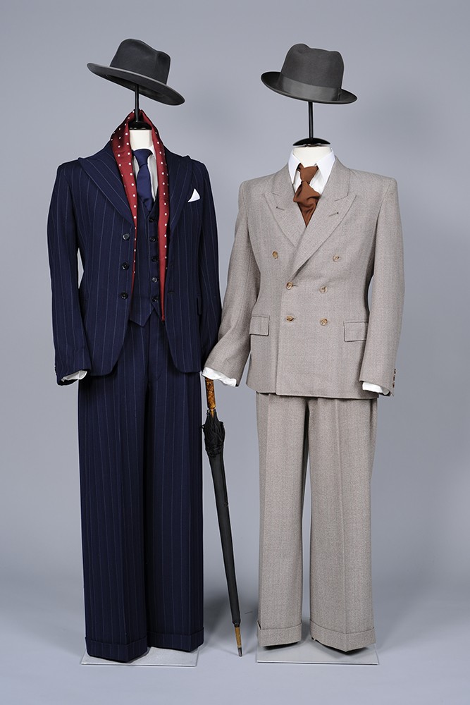 Zwei Herrenanzüge aus Wolle und Kunstseide mit Krawatten und Hüten