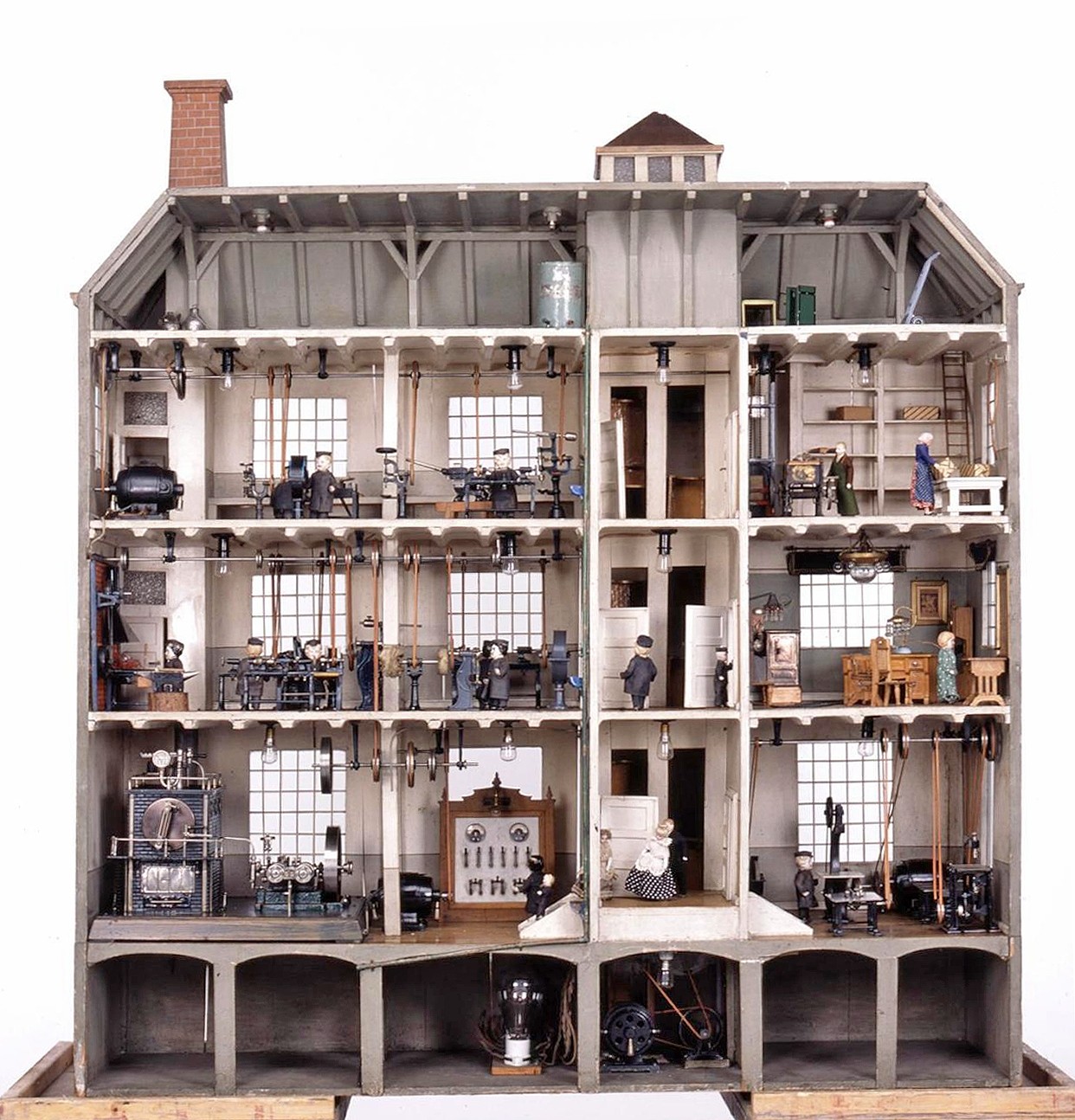 Vierstöckiges Modell einer Fabrik, zur Seite hin geöffnet und detailreich mit Maschinen und Puppen ausgestattet