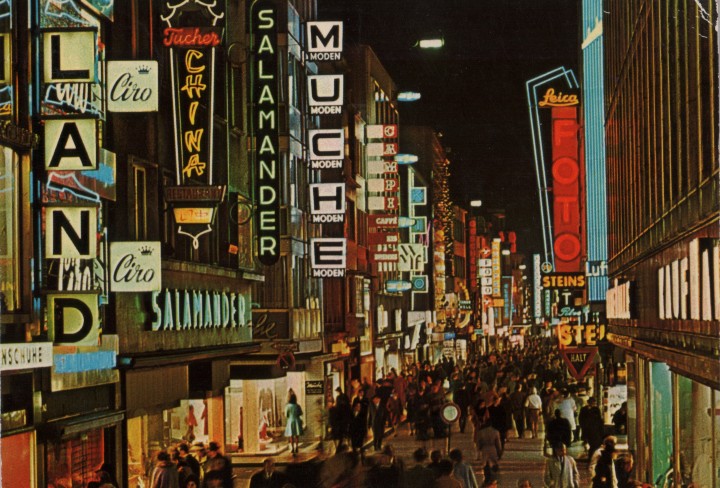 Historisches Foto einer bunt beleuchteten Einkaufsstraße im Dunkeln