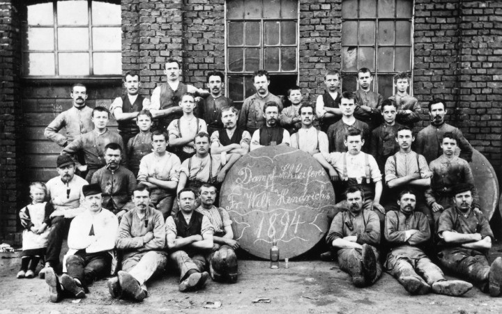 Historisches Schwarzweiß-Foto einer Gruppe Männer in Arbeitskleidung