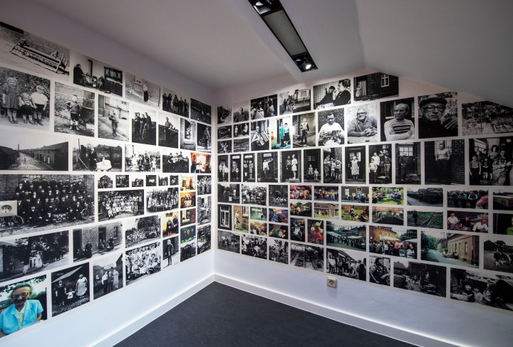 Mann schaut auf zwei Wände an denen Fotografien hängen