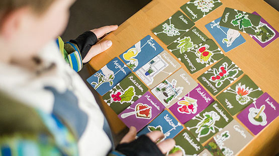 Ein kleiner Junge hält ein Brett voller Spielkarten.
