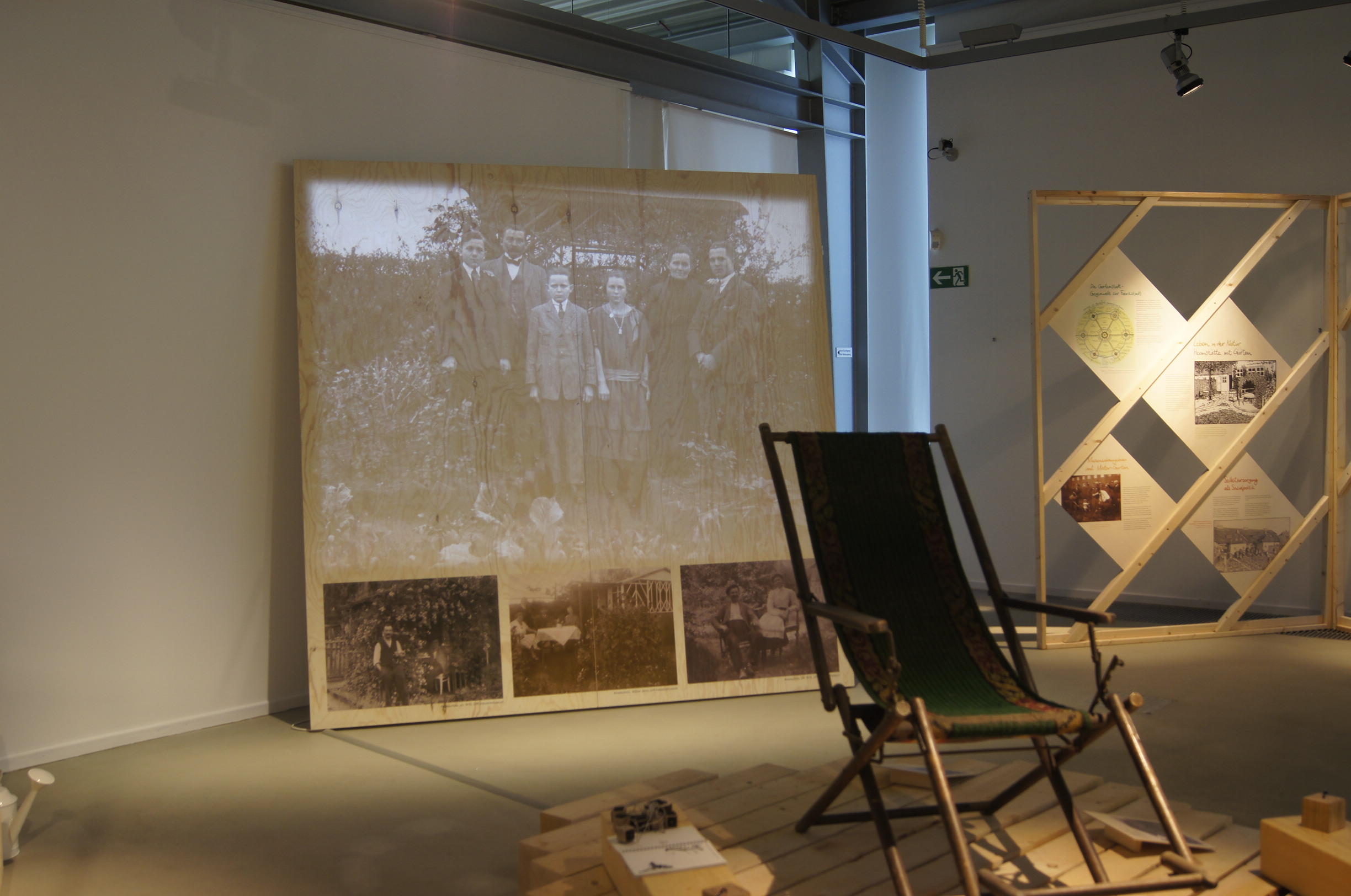 Ein Liegestuhl, im Hintergrund eine Projektion mit historischen Fotos auf Großleinwand.