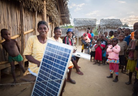 Frau in einem Dorf in Madagaskar hält Solarzelle