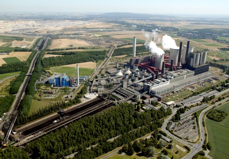 Luftaufnahme einer riesigen Industrieanlage mit rauchenden Schornsteinen
