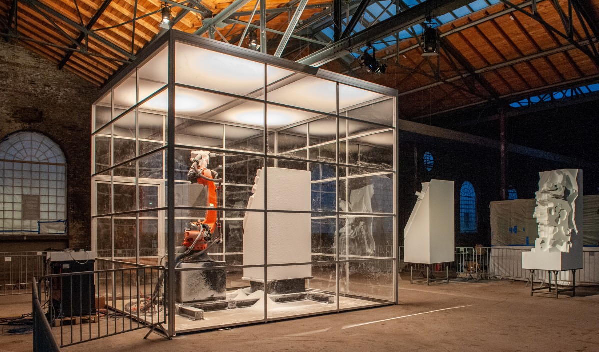 Ein industrieroboter modelliert eine Skulptur in einer Fabrikhalle