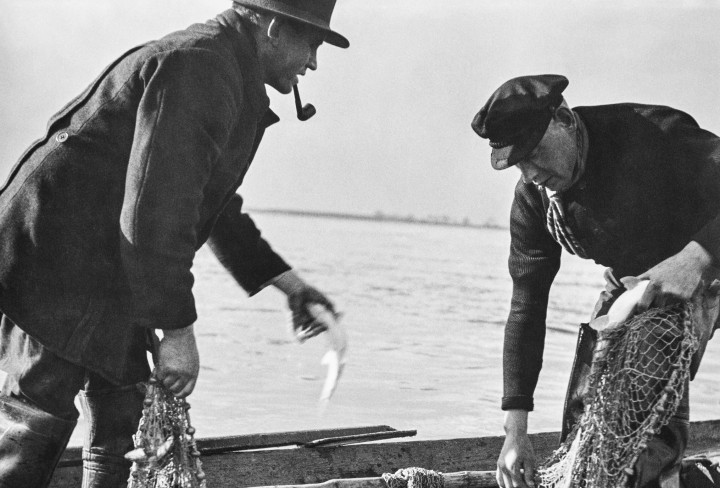 Schwarz-Weiß Bild mit zwei Fischern auf Boot mit Netz 