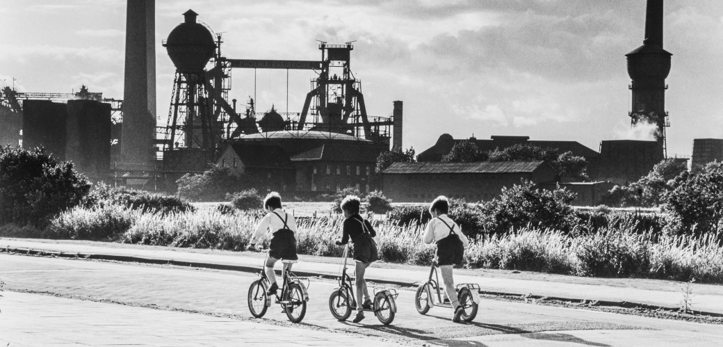 Drei Kindern auf Fahrrädern von Industriekulisse