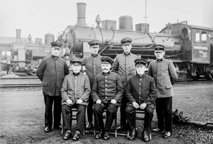 Jubilarians of the factory railroad stand in front of a railroad. The picture is from the 1930s.