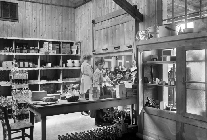 Historisches Schwarz-Weiß Foto zeigt zwei Damen, die Waren aus in einer Kantine ausgeben
