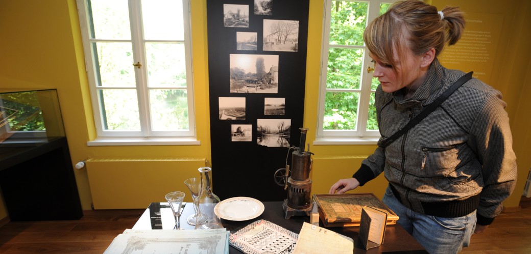 A lady in front of a table with exhibits in the museum