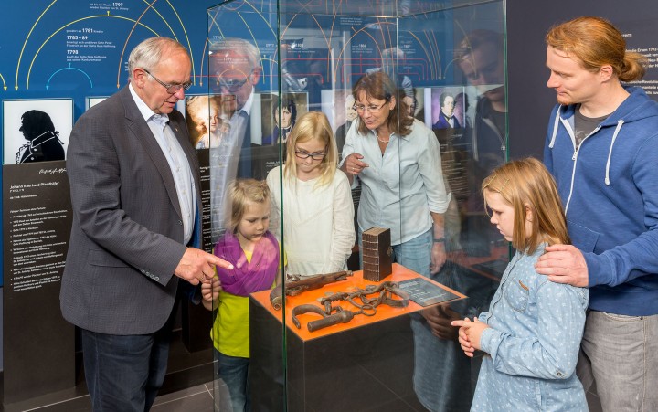 Family looks at a showcase with exhibits
