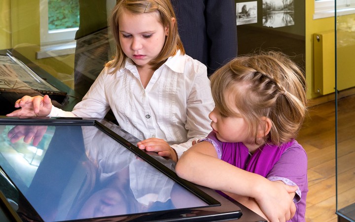 Two children look at a tablet