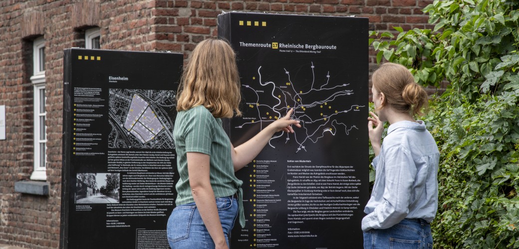 Zwei Frauen betrachten gemeinsam die Infostelen der Siedlung Eisenheim.