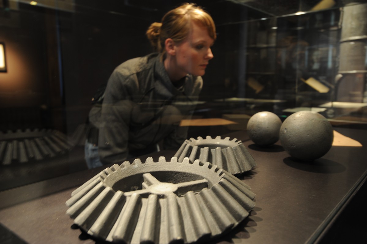 Lady looks into a showcase that contains products made of iron and steel.