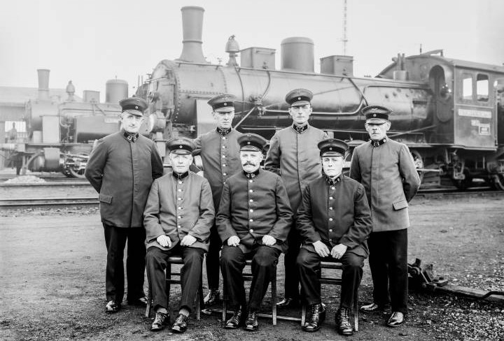 Jubilare der Werkseisenbahn stehen vor einer Eisenbahn. Das Bild ist aus den 1930er Jahren.