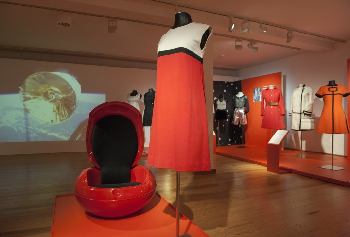 Foto zeigt einen roten modernen Sessel und ein rot-weißes Kleid auf einer Büste