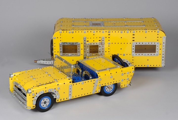 Modell eines gelbes Cabrios mit mit Wohnwagen