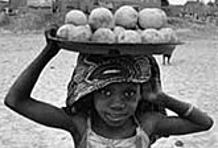 Afrikanisches Mädchen mit Trageschale auf dem Kopf