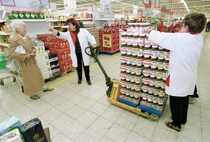Zwei Verkäuferinnen verschieben und sortieren Produktpaletten in einem Supermarkt