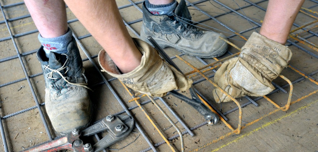 Schuhe und Hände eines arbeitenden Handwerkers