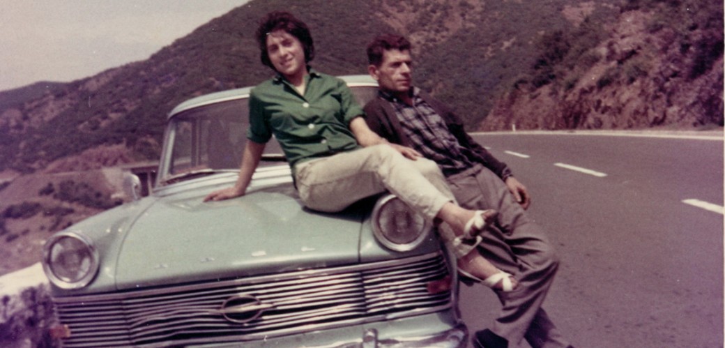 Auf Urlaubsreise nach Griechenland, Pause in Jugoslawien nahe Skopje, kurz vor der Grenze zu Griechenland. Elena Kontogianni – auf der Motorhaube – freute sich wie immer riesig auf zu Hause, rechts der Vater. Die Aufnahme entstand 1965.