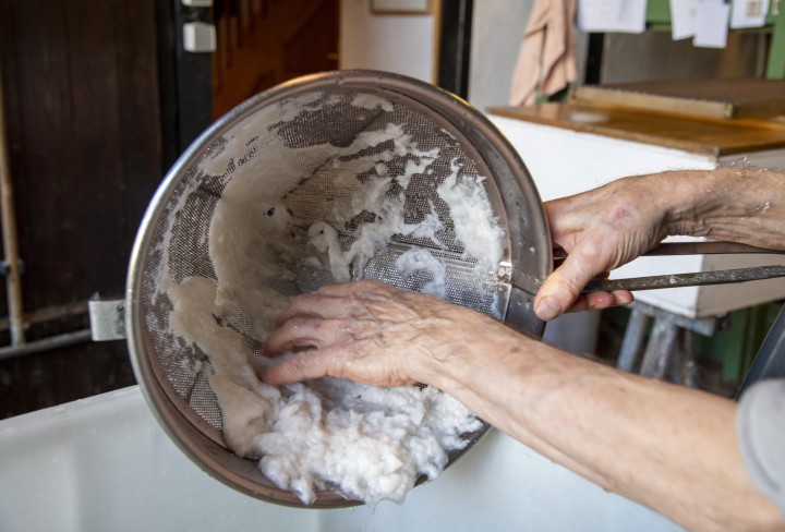 Papierfasern: Der Faserbrei wird abgesiebt und von Hand weiterverarbeitet