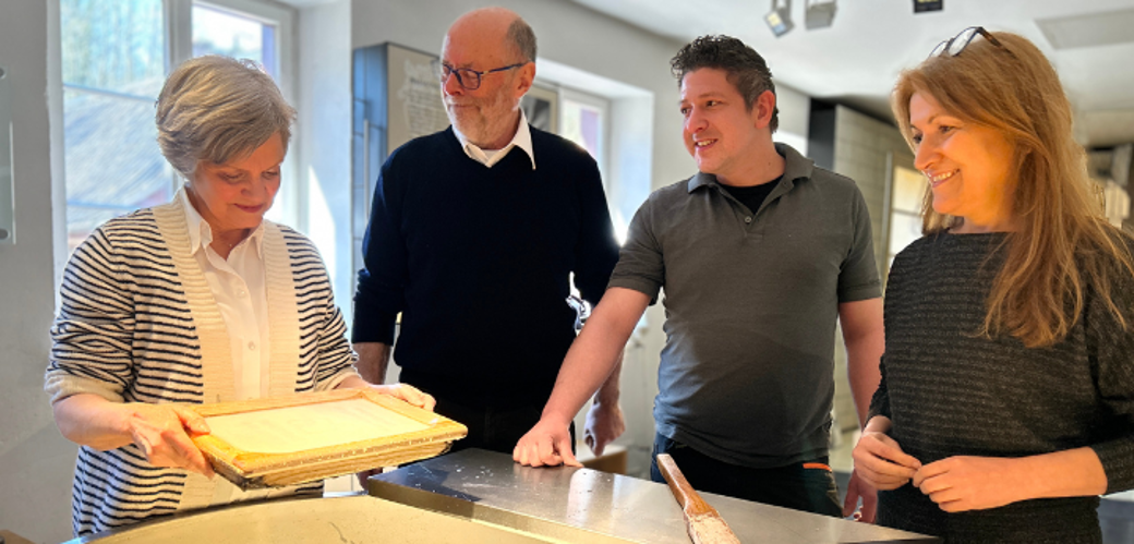 Vier Erwachsene beim Papier schöpfen