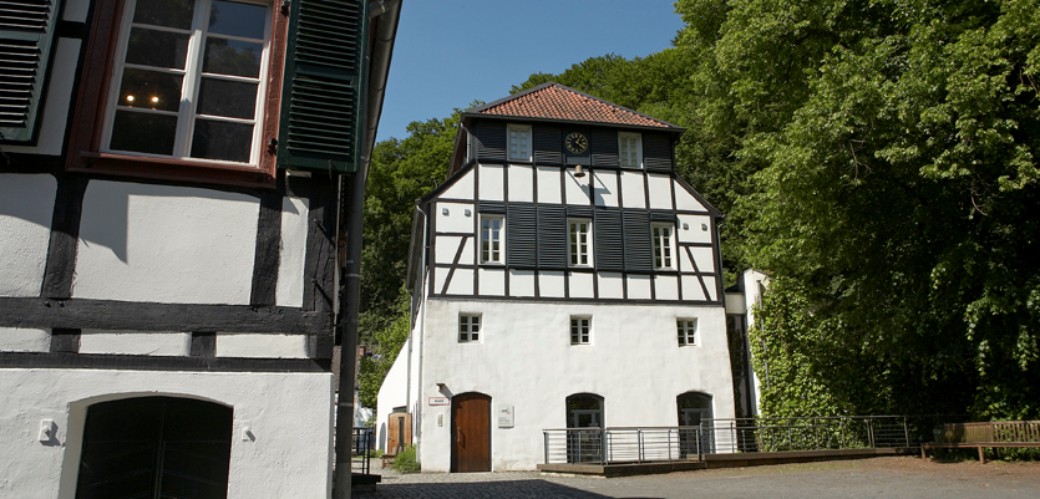 Sommerliche Außenansicht der Fachwerkhäuser der historischen Papiermühle Alte Dombach