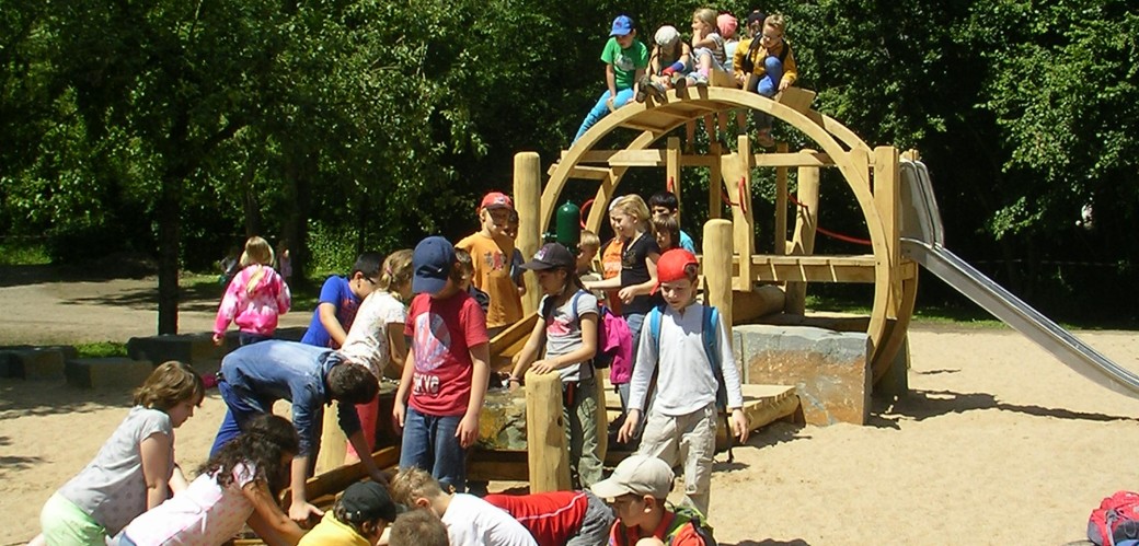 Viele Kinder auf einem Spielplatz im Sand