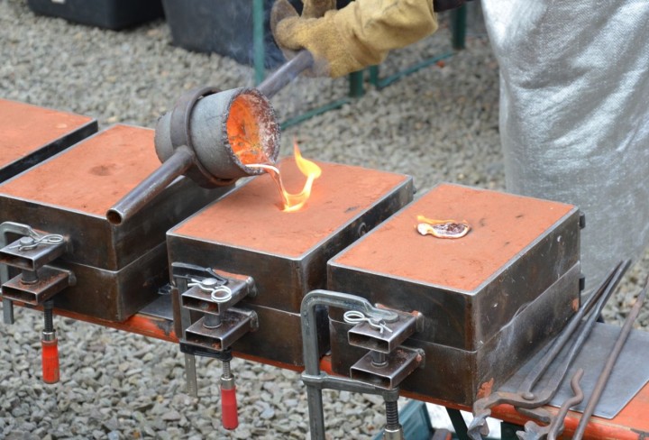 Jemand gießt gerade flüssiges Metall in eine Form.